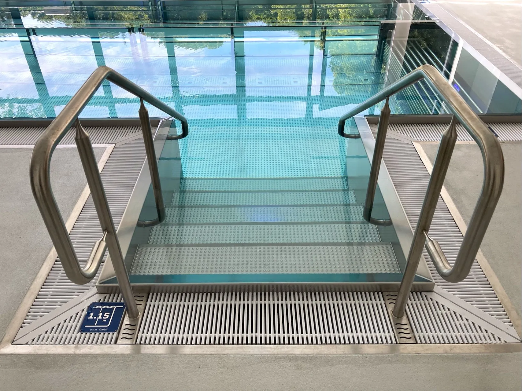 Escalier d'accès en inox à double main courante, descendant dans un bassin de balnéothérapie.
